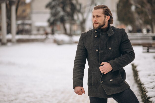 Photo bearded man posing in the street in winter