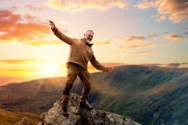 Bearded Man reaching the destination and on the top of mountain at sunset on autumn day