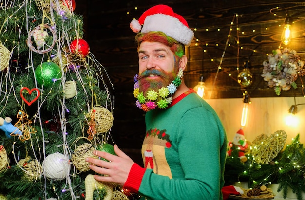 Bearded man in santa hat near christmas tree happy new year christmas beard decorations