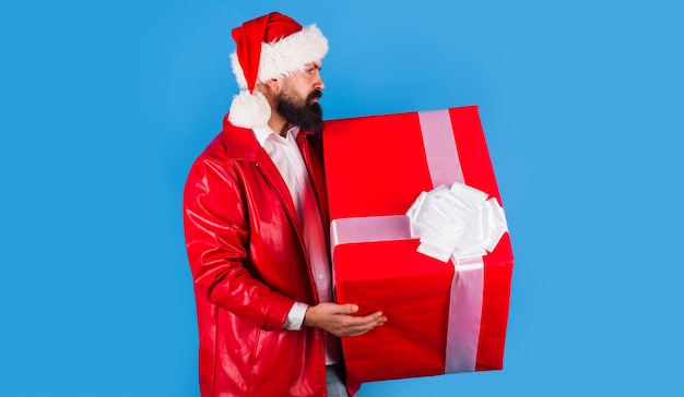 Bearded man in santa hat with big present delivery new year gifts merry christmas