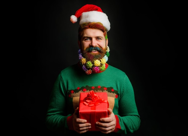 Bearded man in santa hat with present gift box merry christmas and happy new year