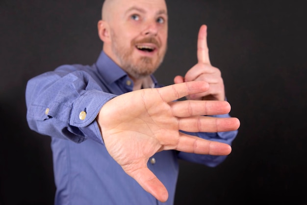 Bearded man shows one hand up and another stop sign