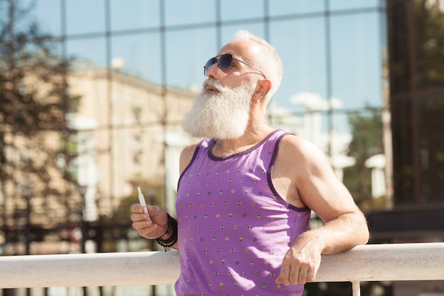 Bearded man smoking electronic cigarette. New technology of healthy smoking. IQOS.