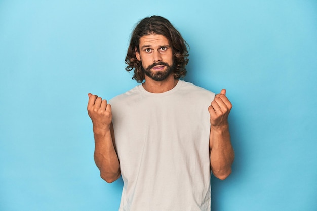 Photo bearded man in a tank top blue backdrop showing that she has no money