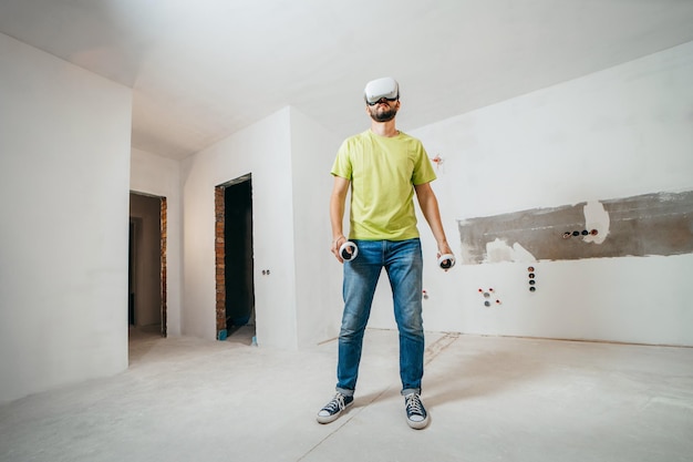 Bearded man using virtual reality goggles before starting renovations in his townhouse