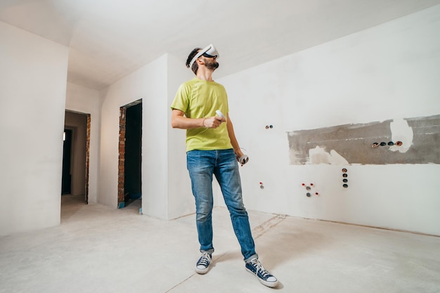 Bearded man using virtual reality goggles before starting renovations in his townhouse