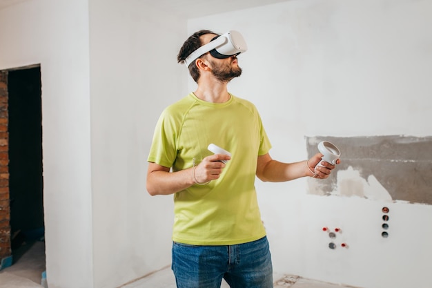 Bearded man using virtual reality goggles before starting renovations in his townhouse