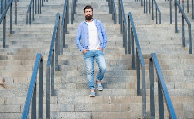 Bearded man walking downstairs full length of man with beard hipster man outdoor at stairs