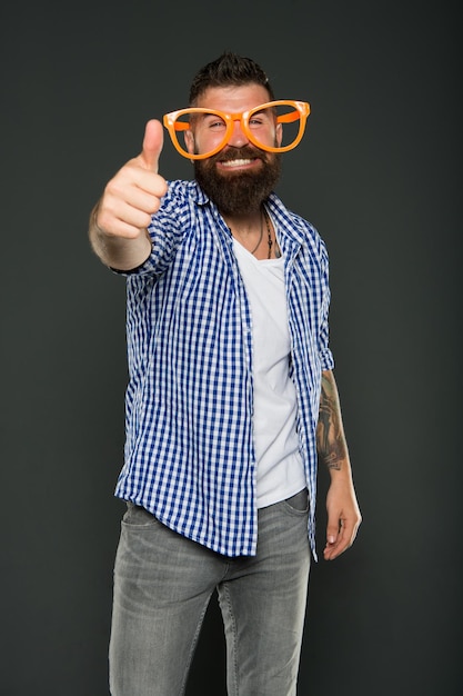 Bearded man wearing party glasses Funny hipster in extravagant glasses Fashion man with beard Playful guy enjoying party Funny glasses accessory Entertaining himself Only fun on my mind