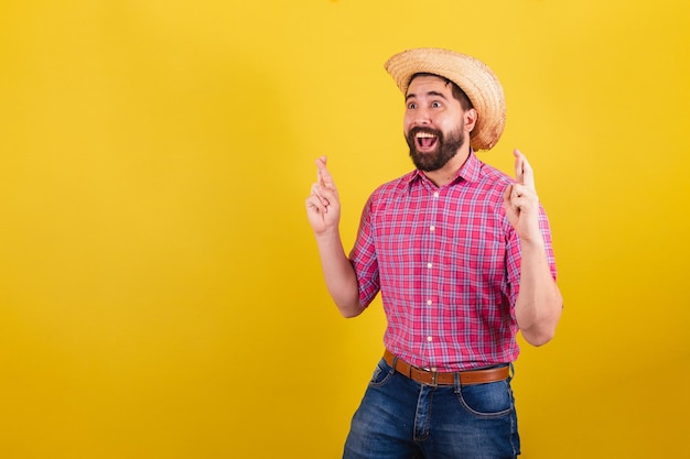 Bearded man wearing typical clothes for party Junina Fingers crossed wishing hoping wishing so badly luck For the Arraia Party