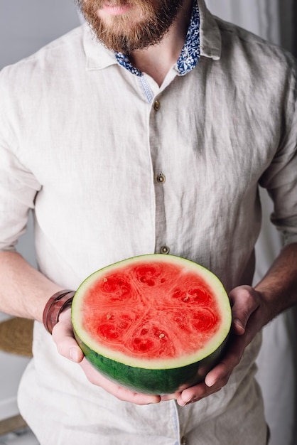 Bearded man with half of watermelon