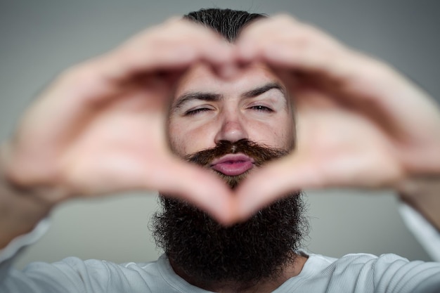 Bearded man with hands in heart shape