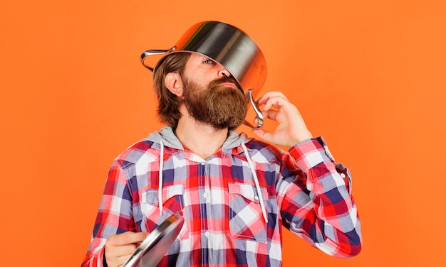 Bearded man with saucepan or pot on head kitchenware cooking utensils kitchen advertising