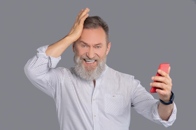 Bearded man with a smartphone in hands