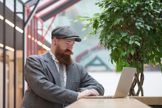 Bearded man in wool blazer working on laptop