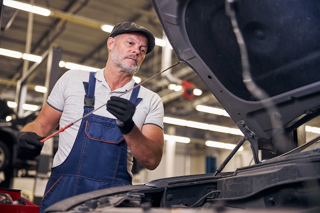 Bearded man working at car repair service station