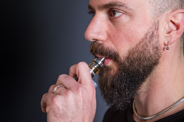 Beared man  smoking electronic cigarette