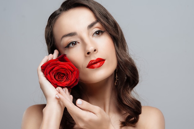 Beauteous brunette woman with red lipstick on lips.