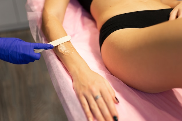 Beautician applies depilation gel