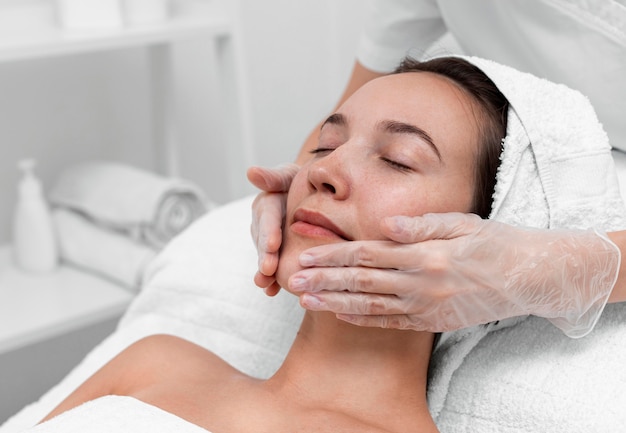 Beautician doing face beauty routine for female client