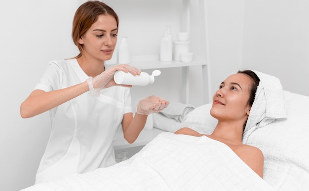 Beautician doing face beauty routine for female client