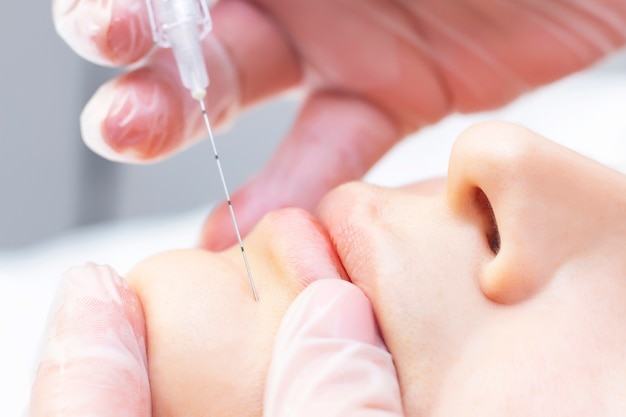 Beautician Injecting collagen Into The Chin