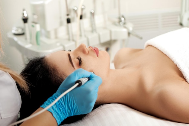 Beautician makes Ultrasonic cleaning of the face in spa salon. cosmetology