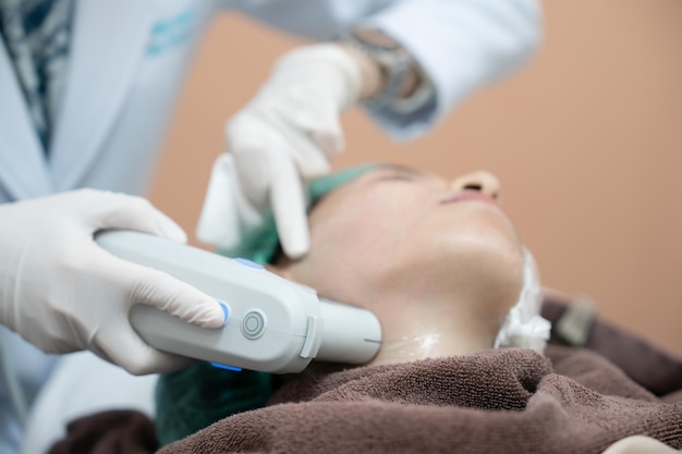 Beautician procedure by electric deviceUltrasound therapy treatment for skin tightening in aesthetic clinic