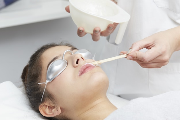 Beautician Removing Hair Of Young Woman with laser