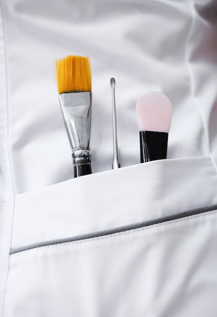 Beautician's tools in the pocket of a white medical coat