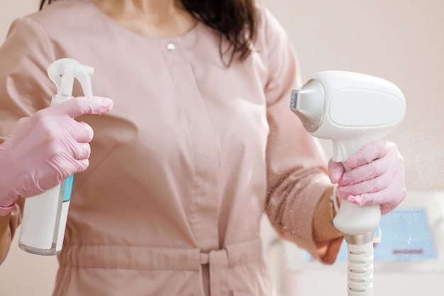 Beautician treats her equipment with an antiseptic close up of female beautician in sterile gloves