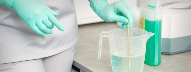 The beautician uses a stick to mix disinfectant into the water. Sterilization of tools.