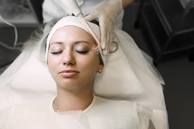 beautician using a power tool to cleanse the patient's skin