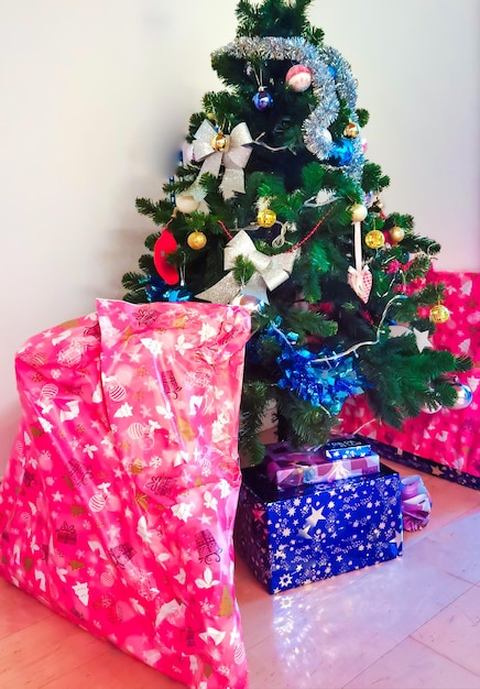 Beautifly decorated christmas tree with lots of gifts around it.