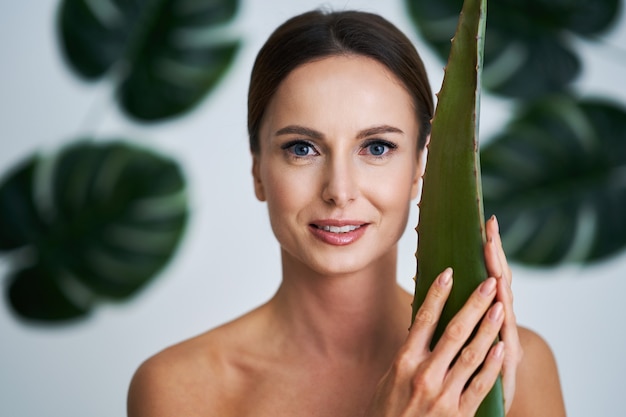 beautiful adult woman posing against leaf background