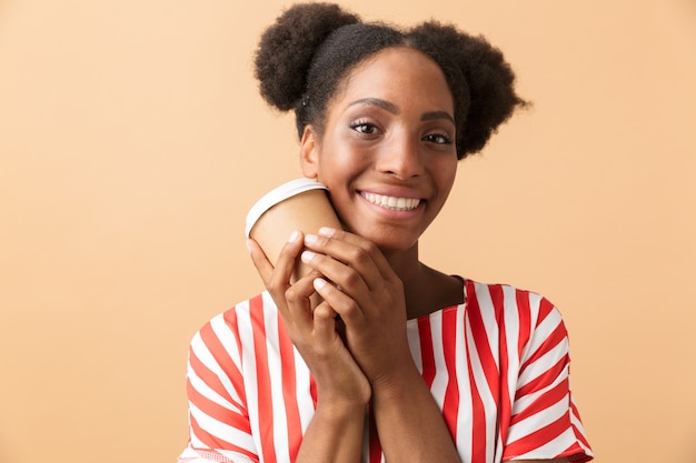 Beautiful african american woman in casual clothing holding paper cup with takeaway coffee, isolated