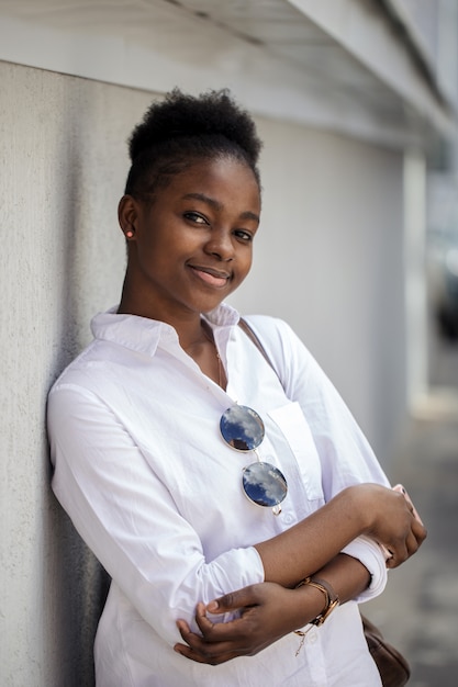 Beautiful african american woman in the street against the white wall