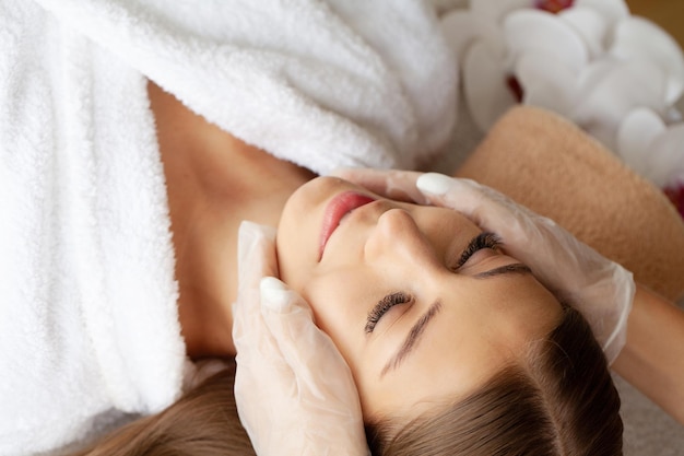 Beautiful african woman getting face massage in beauty spa