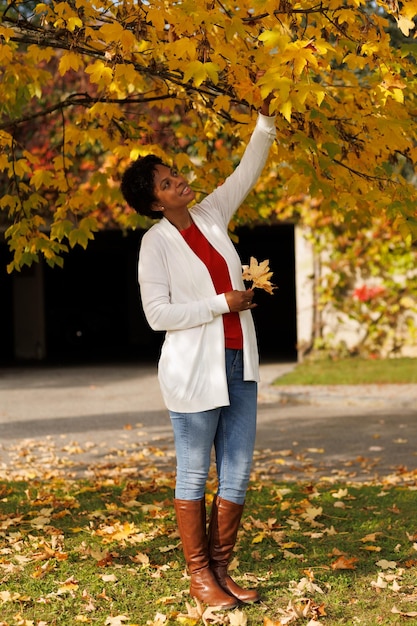 Beautiful AfricanAmerican woman walking in an autumn garden