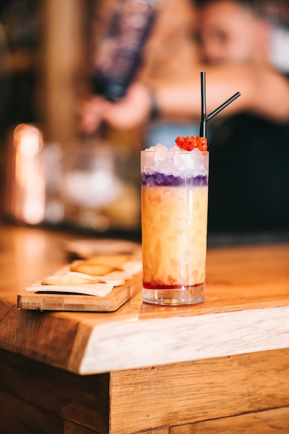 Beautiful alcoholic cocktails on wooden bar counter and cheese snack