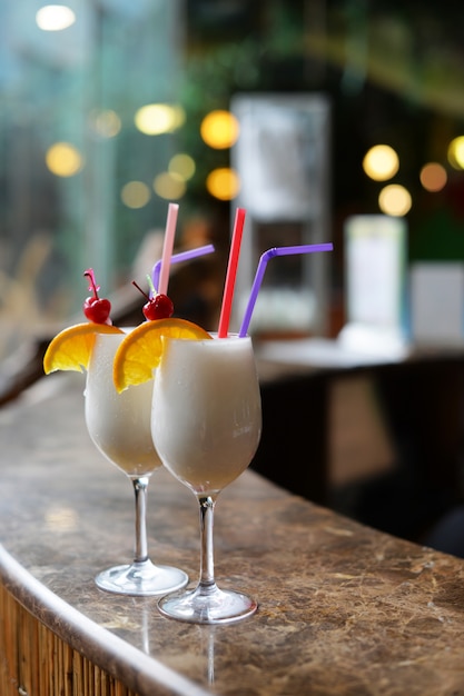  beautiful alcoholic drinks cocktails with pineapple pinacolada and coconut on the bar counter 