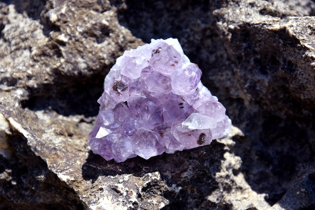 A beautiful amethyst druze lies on a stone A splice of purple crystals of semiprecious quartz