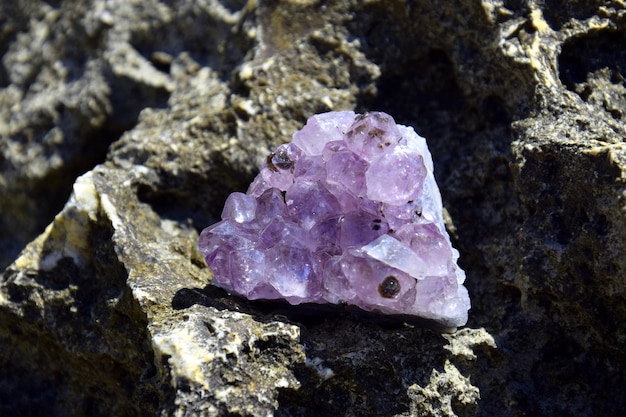 A beautiful amethyst druze lies on a stone A splice of purple crystals of semiprecious quartz