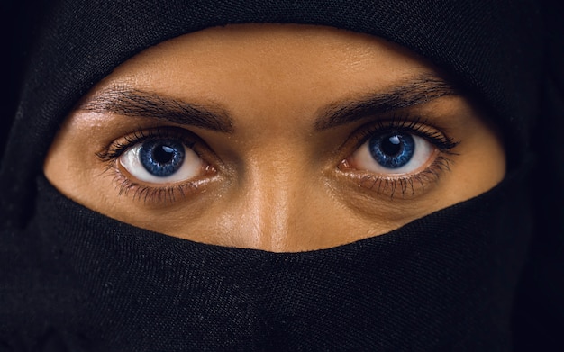 Beautiful Arabic woman in hijab with bright makeup and blue eyes