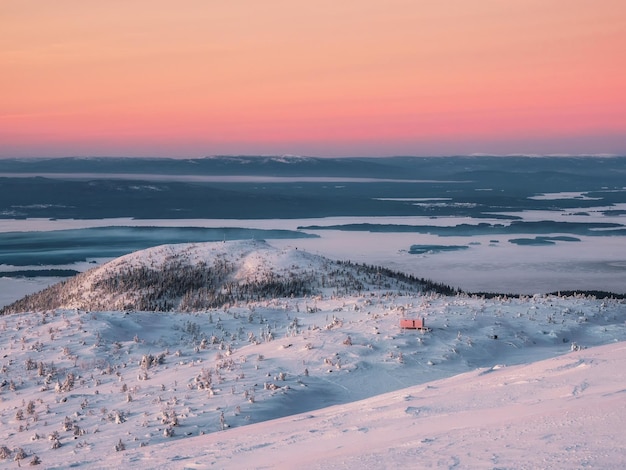 Beautiful Arctic sunset Scenic colorful sky at dawn Winter time Cabin in winter Dubldom on the mountain Volodyanaya Kandalaksha Murmansk region in Russia