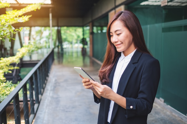 A beautiful asian businesswoman holding and using mobile phone in the office