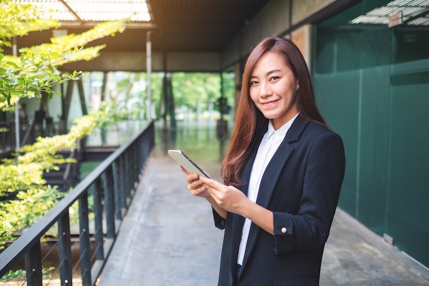 A beautiful asian businesswoman holding and using mobile phone in the office