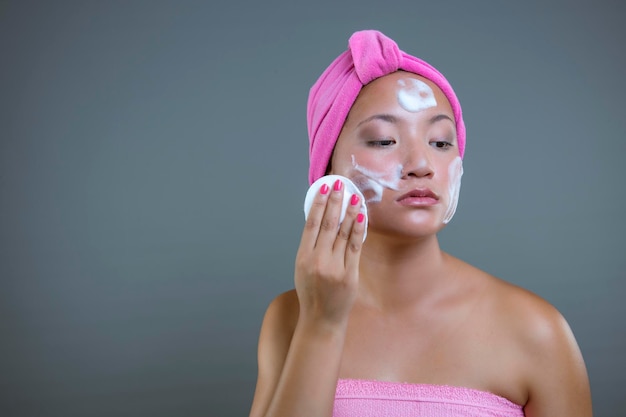 Beautiful asian ethnicity woman cleaning her face