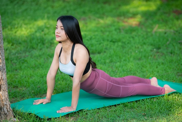 Beautiful asian fat woman play yoga at the parkNeed to slim fit body