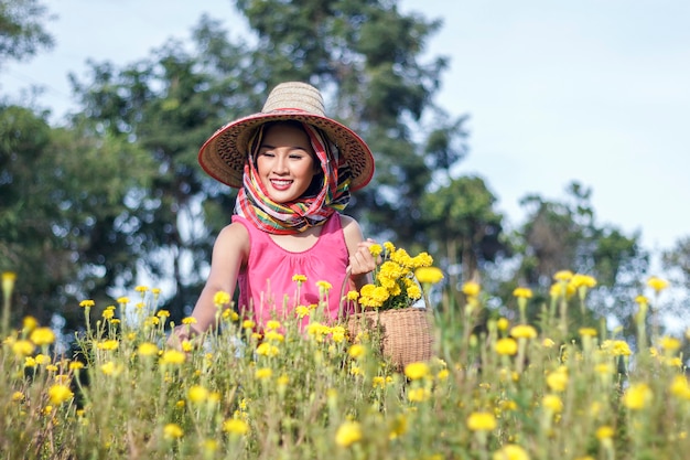 Beautiful asian gardener girl in marigold flowers field 